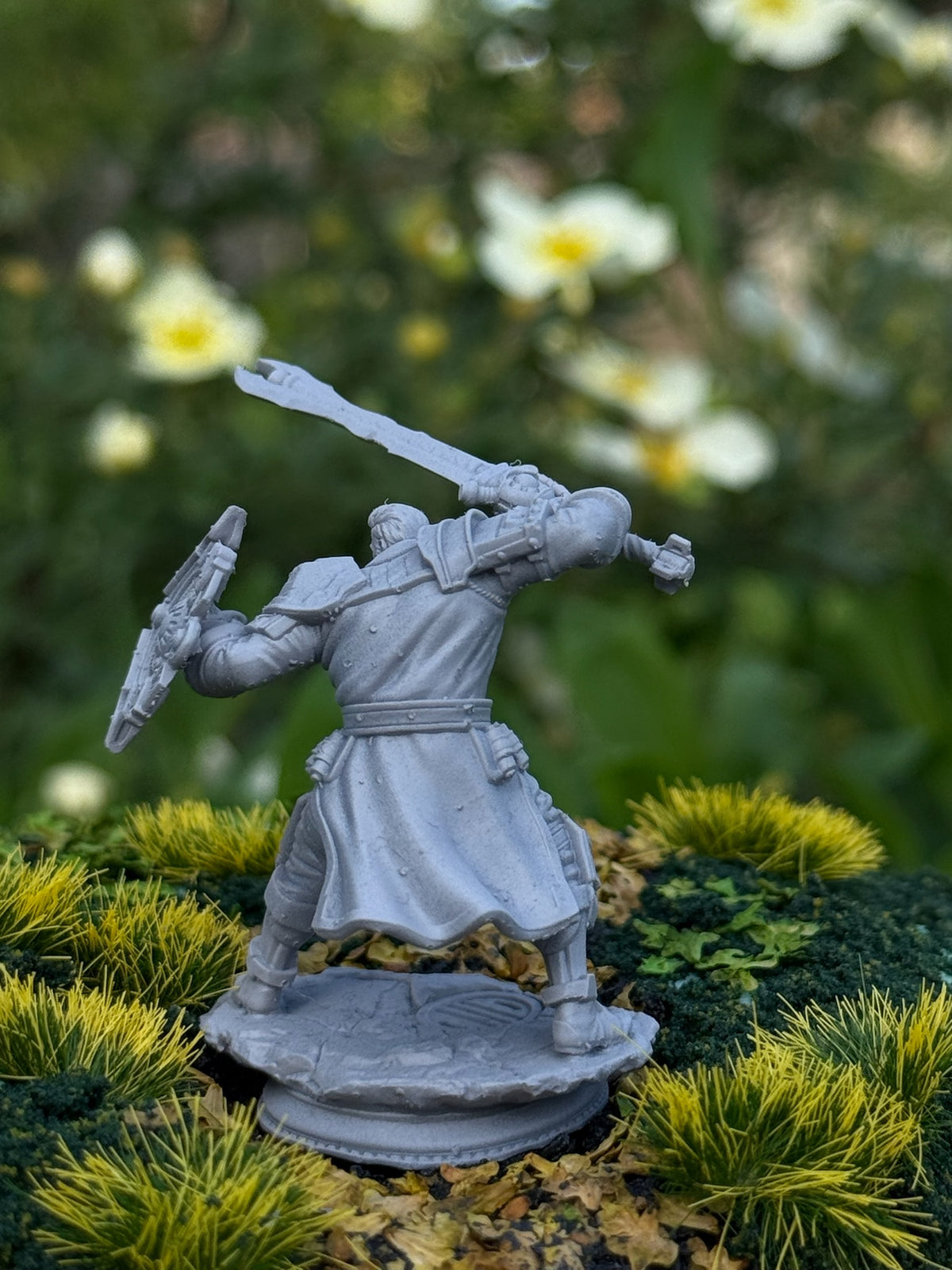 Primed 3D-printed fantasy warrior miniature with sword and shield on a mossy base, Fabulous Tavern of Miniatures