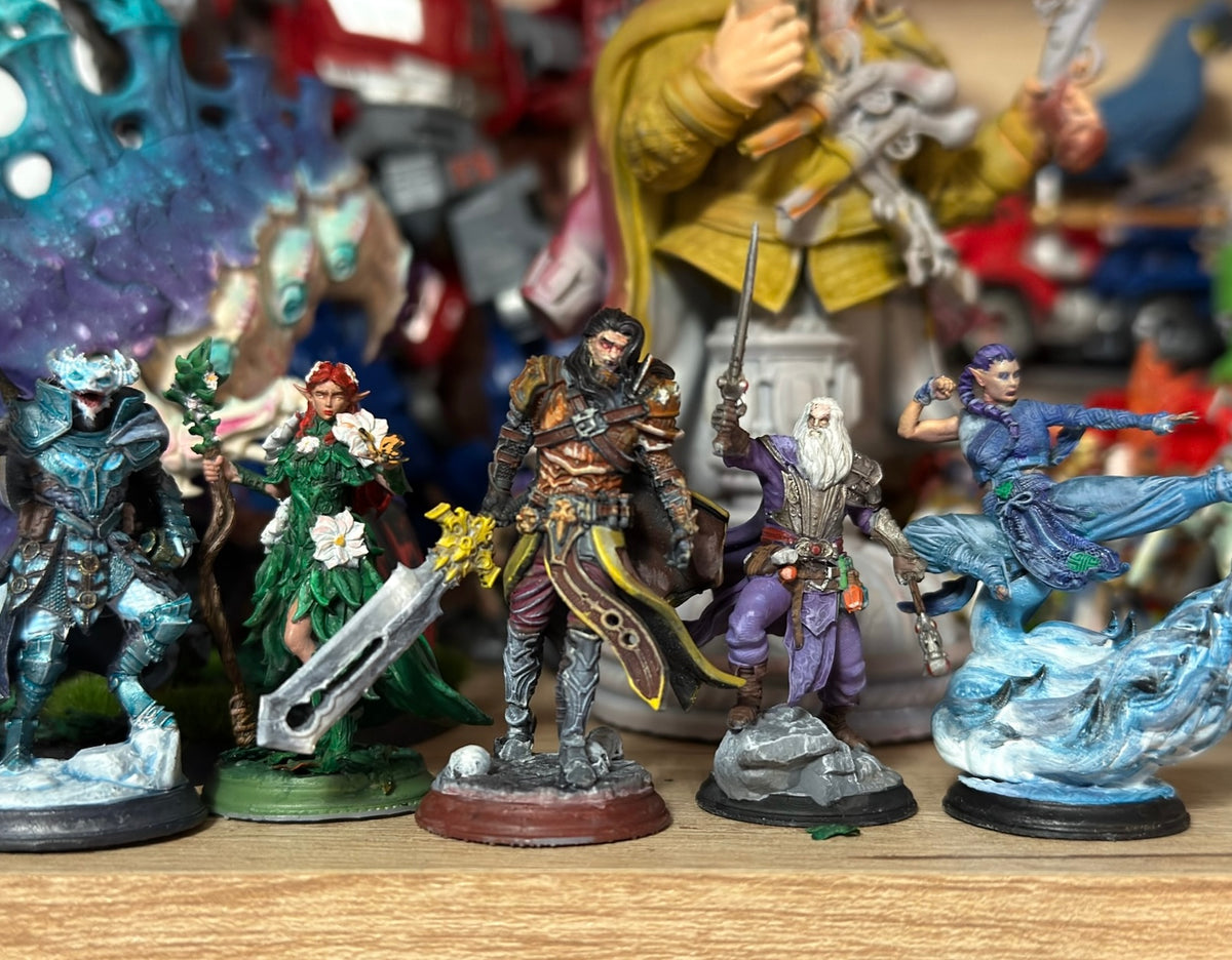 Lineup of painted fantasy miniatures on a wooden table